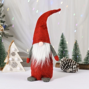 Detail of red Christmas gnome plush decoration with long white beard and festive lighting