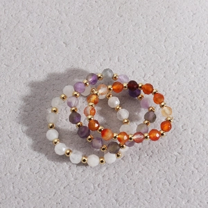 Macro detail of elastic natural stone beaded ring set with amethyst and moonstone beads