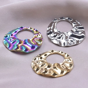 Detailansicht geometrischer Ohrringe mit unregelmäßiger Textur in Gold, Silber und Regenbogen