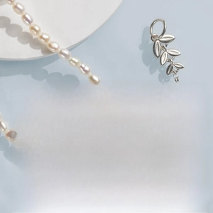 Macro detail of natural freshwater rice pearl necklace with silver leaf pendant