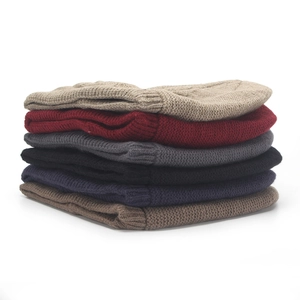 Detailed stack of ribbed knit beanies showing various colors including red, beige, and blue