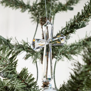 Clear acrylic cross ornament with faceted crystal design hanging on a Christmas tree