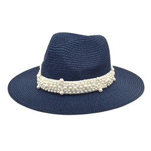 Detail of navy straw fedora hat featuring white ribbon and elegant pearl embellishments