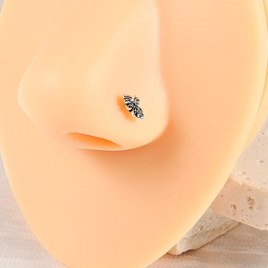 Macro shot of stainless steel moth nose stud with black and white texture on silicone model
