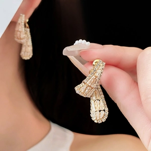 Vue macro de boucles d'oreilles en éventail avec zircons rectangulaires et placage d'or