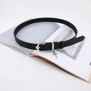 Close-up of black leather belt with silver pin buckle and hanging cross charm detail