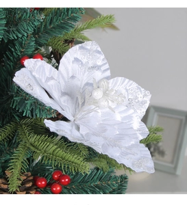 Detail of white Christmas flower with silver sequins, berries, and pine cones
