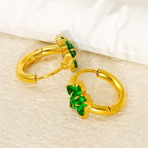 Detail of gold flower hoop earrings with five green zircons and polished finish