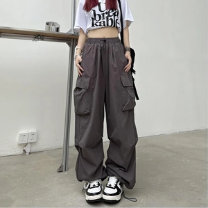 Detail shot of loose dark grey cargo pants featuring functional multi-pocket design