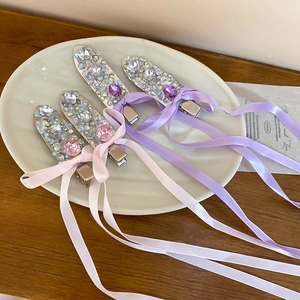 Detailed view of handmade bow hair clips with rhinestones and long silk ribbons