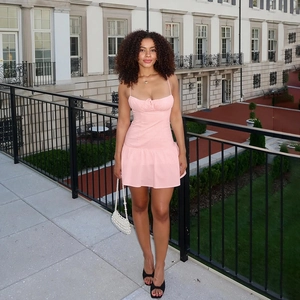 Détail de la mini robe rose moulante avec buste froncé et ourlet à volants