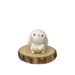 Handcrafted white rabbit wood carving ornament on a natural wooden bark base