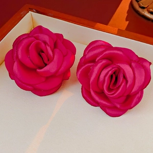 Detailed close-up of rose red velvet flower necklace featuring rich satin fabric texture