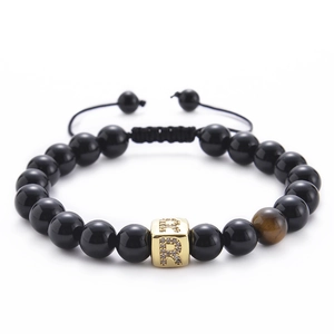 Detail of tiger eye stone bead and micro-pave zircon letter R on black onyx bracelet