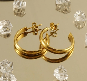 Close-up of golden stainless steel hoop earrings with a matte brushed finish