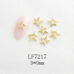 Détail bijou d'ongle étoile évidée dorée sur ongles rose clair, taille 9x9mm