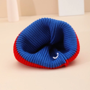 Winter knitted beanie hat in blue and red color-block design with warm thick ribbed texture
