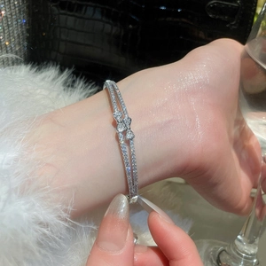 Close-up of double-row 18k gold plated bracelet with zircons and bow details
