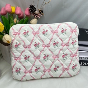 Detailed view of quilted cotton laptop sleeve with floral rose and bow pattern