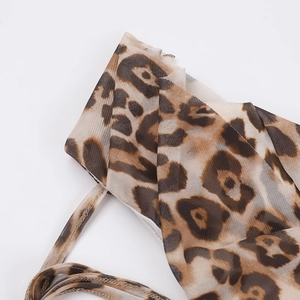 Detailed macro view of semi-transparent leopard print mesh fabric with thin shoulder straps