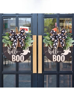 Halloween wooden hello BOO door hanger with ghost pattern bows on black glass doors