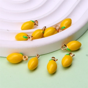 Detailed macro shot of yellow lemon fruit charms with green leaves for DIY jewelry making