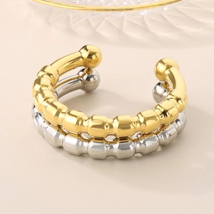 Close-up of dual-layer beaded texture on 18k gold and silver C-shaped cuff bracelets