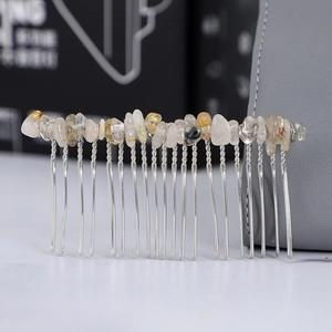 Detailed view of handmade silver metal hair comb with white crystal stones and wire wrap