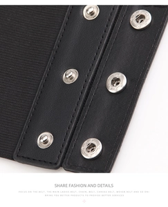 Detail of black elastic waist belt featuring leather patchwork and metal snap buttons