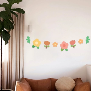 Ghirlanda di fiori e foglie colorate sopra il divano per decorazione festa di compleanno