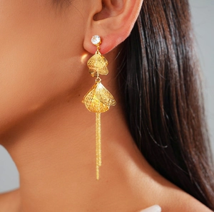Gros plan de boucles d'oreilles pétales évidés plaqués or 18k avec zircon et pompons