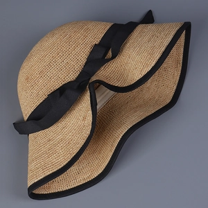 Eleganter faltbarer Raffia-Sonnenhut mit breiter Krempe und schwarzer Schleife für den Sommer