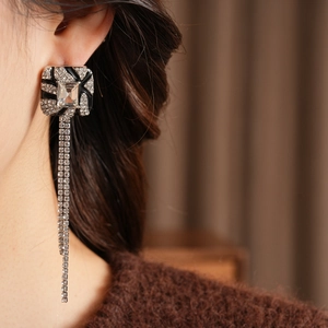 Close-up of elegant square tassel earrings with rhinestones and silver needle finish