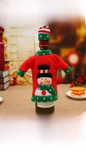Detail of Christmas wine bottle cover with knit sweater, snowman patch and mini hat
