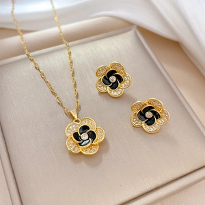 Elegant gold-tone camellia jewelry set with black enamel and white zircon inlay