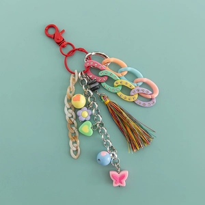 Detail of acrylic keychain with tassels, macaron chain and butterfly heart charms