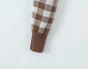 Close-up of ribbed cuffs and brown checkered knit texture on long sleeve cardigan