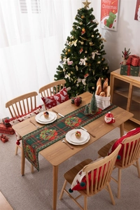 Festive Christmas table runner featuring red-green plaid and floral wreath on wood