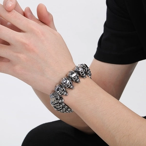 Detailed close-up of a silver skull link bracelet in punk style on a person's wrist