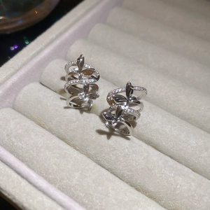 Close-up of sparkling zircon butterfly multi-layer ear cuff on beige velvet tray
