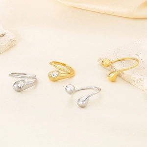 Detailed view of teardrop and bead style open rings in gold and silver stainless steel