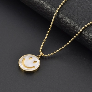 Collier en acier titane doré avec pendentif sourire en nacre blanche et chaîne boule