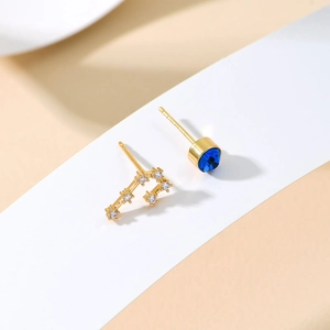 Asymmetric S925 silver stud earrings with blue stone and gold constellation design