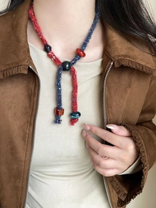 Detail of bohemian hand-woven necklace showing colorful resin beads and cotton rope texture