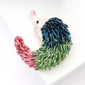 Detail of hedgehog brooch featuring gradient enamel spikes in blue, green and pink