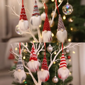 Knitted Christmas gnome ornaments with red and grey snowflake patterns on festive branches