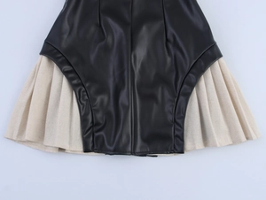 Detail view of the black PU leather splicing and pleated hem on this bodycon mini dress