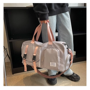 Detailed view of grey travel gym bag with pink straps and multi-pocket functional design
