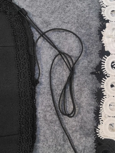 Détails de dentelle évidée noire et blanche avec cordon élastique sur l'ensemble