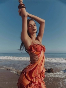 Bohemian beach dress with wave patterns, side cut-outs and ruffled hem in sunset colors